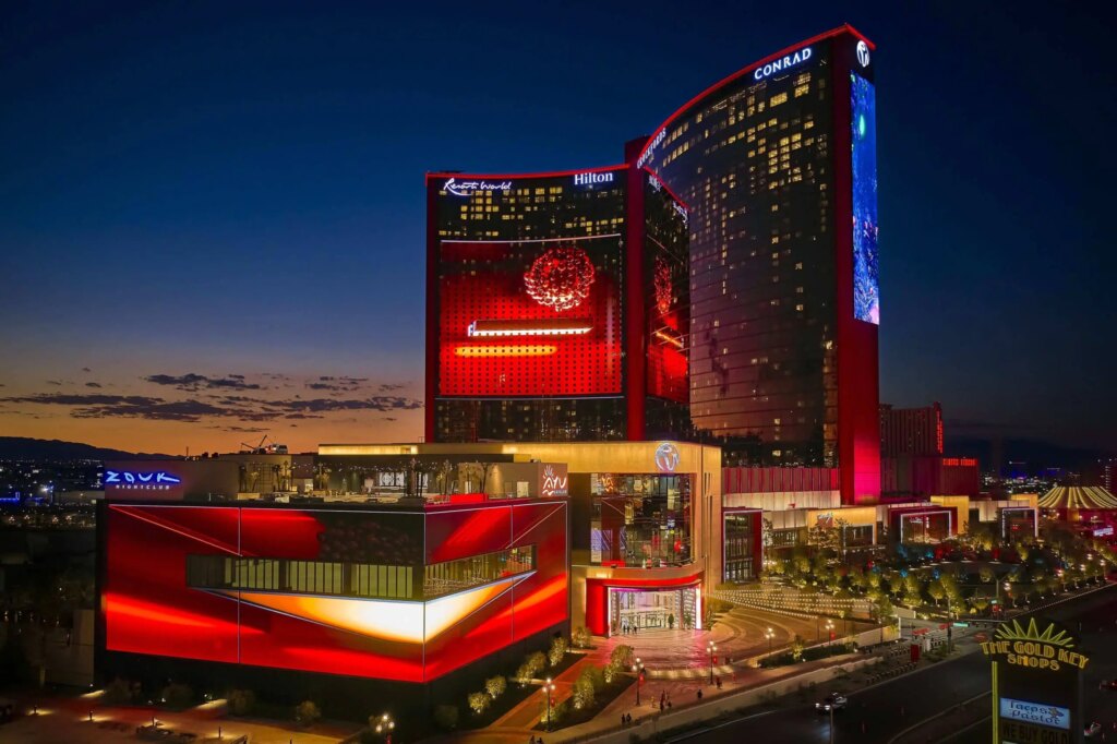 Nightime view of the Resorts World Las Vegas with red neon lights shining